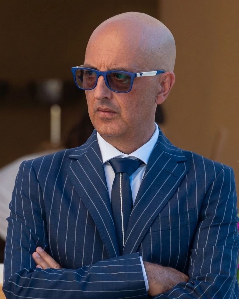 Salvatore De Salvatore, fondatore di DESA Carburanti, in abito gessato blu con le braccia conserte